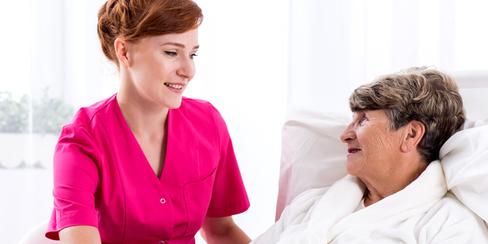 A nurse and an elderly patient read the directions on a medicine bottle.