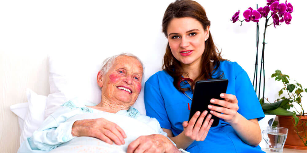 A smiling charge nurse in uniform holding a tab with patient records.