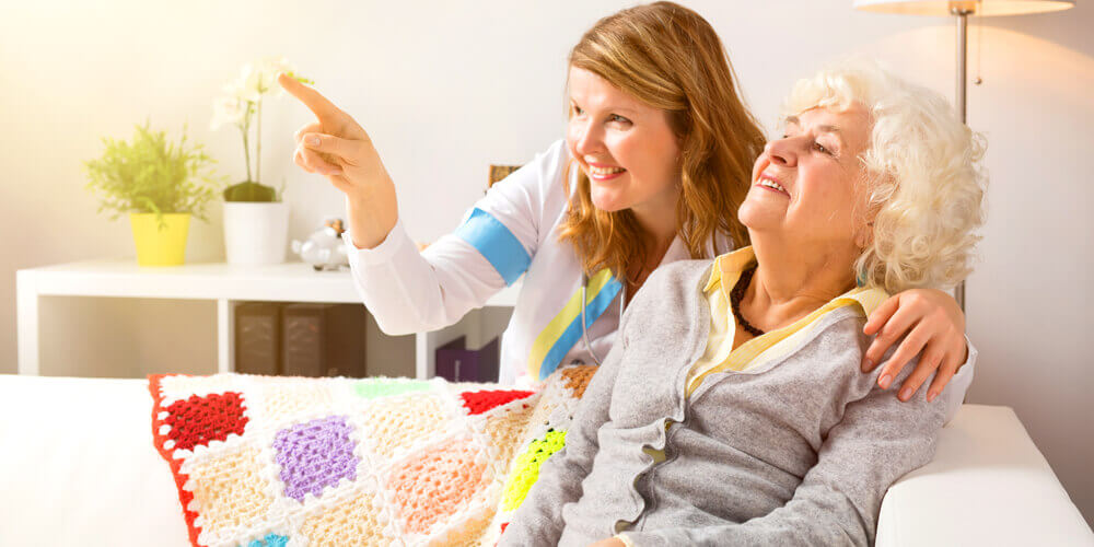 A nurse and an elderly patient read the directions on a medicine bottle.