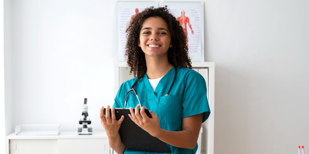 A nurse giving a thumbs up while carrying nursing portfolios in her hands.