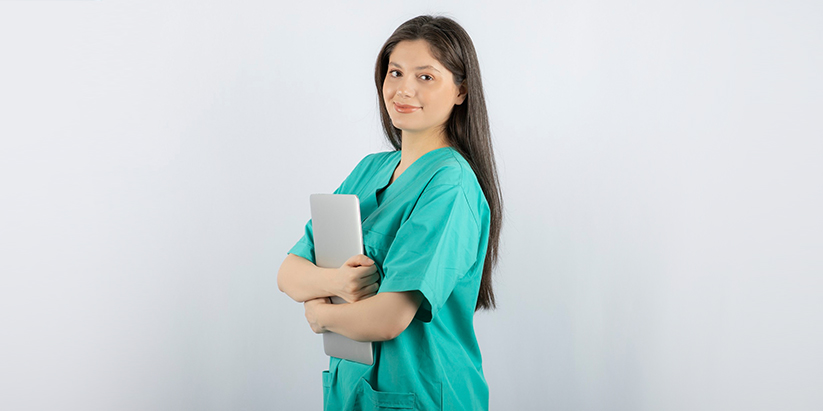 Two nurses converse and take notes about medications in the pharmacy.