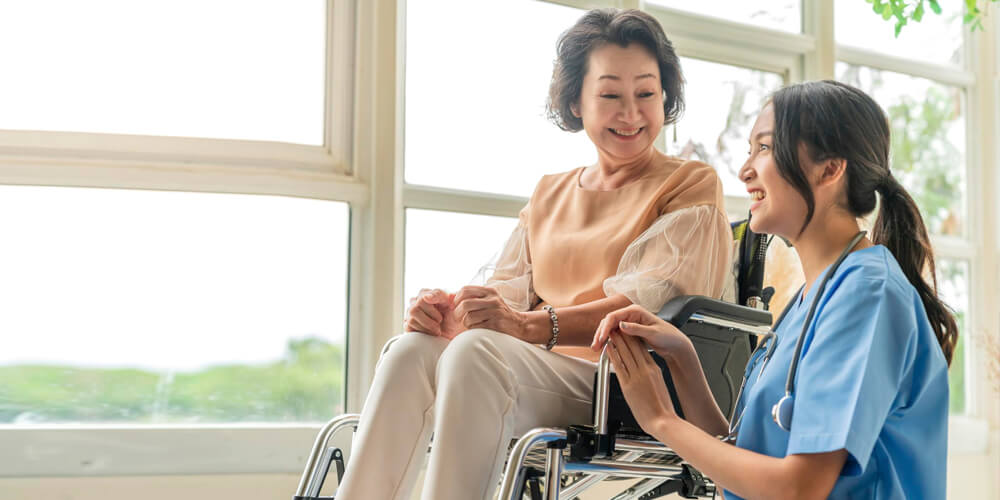 A nurse and an elderly patient read the directions on a medicine bottle.