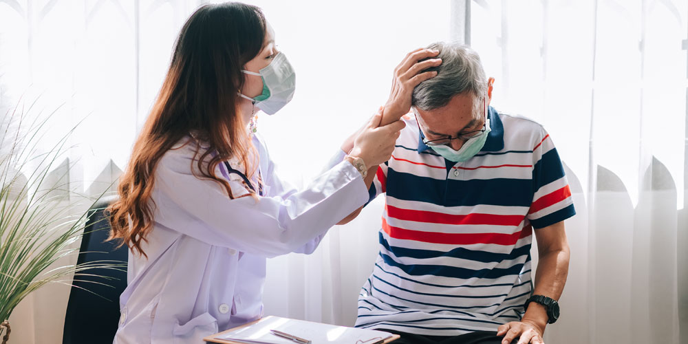 A Nurse professional wearing a mask and disposable gloves in their workplace.