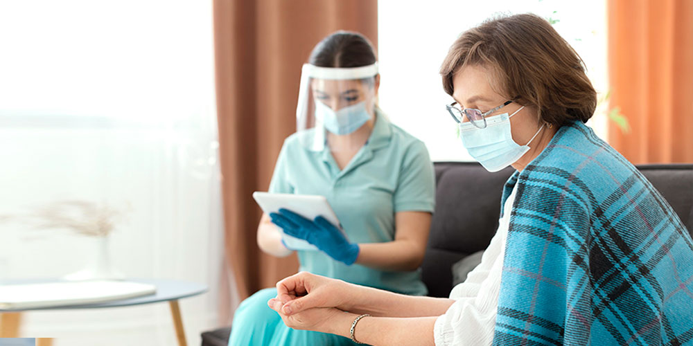 An oncology nurse holding hands of a patient providing compassionate support.