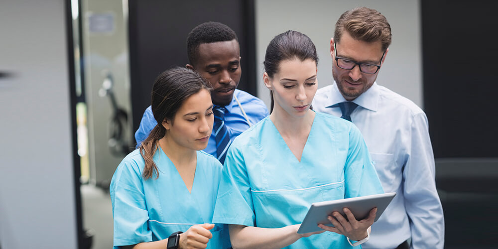 A professional nurse advocate converses with a nurse in an office.