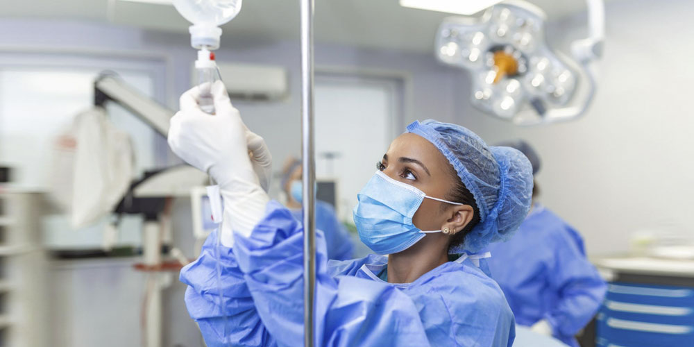 A professional nurse advocate converses with a nurse in an office.