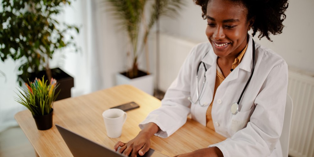 A smiling charge nurse in uniform holding a tab with patient records.