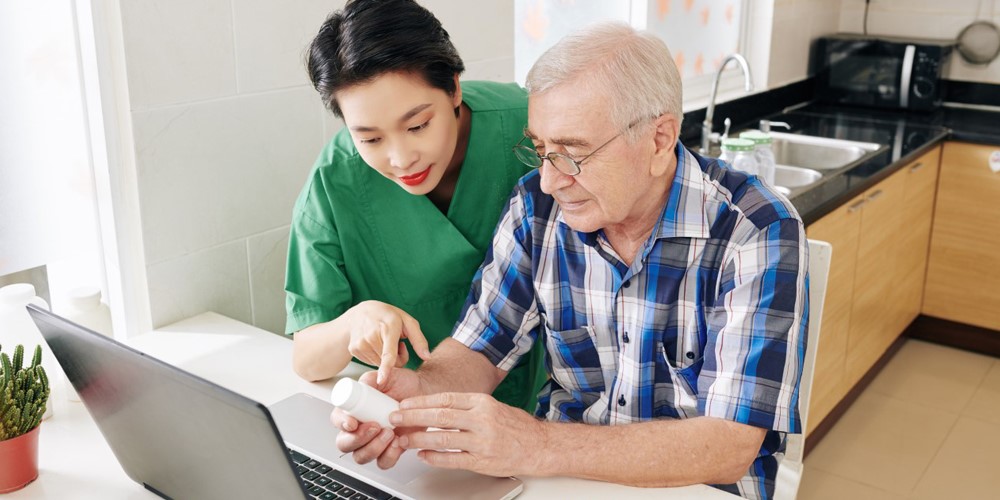 An oncology nurse holding hands of a patient providing compassionate support.