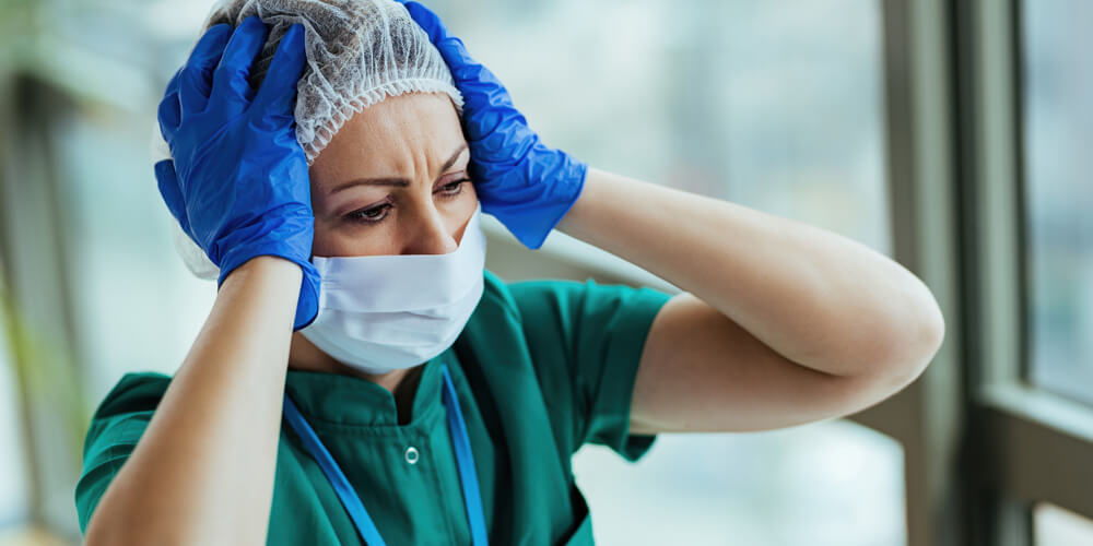 A nurse is helping another healthcare staff do a workout to de-stress and relax.