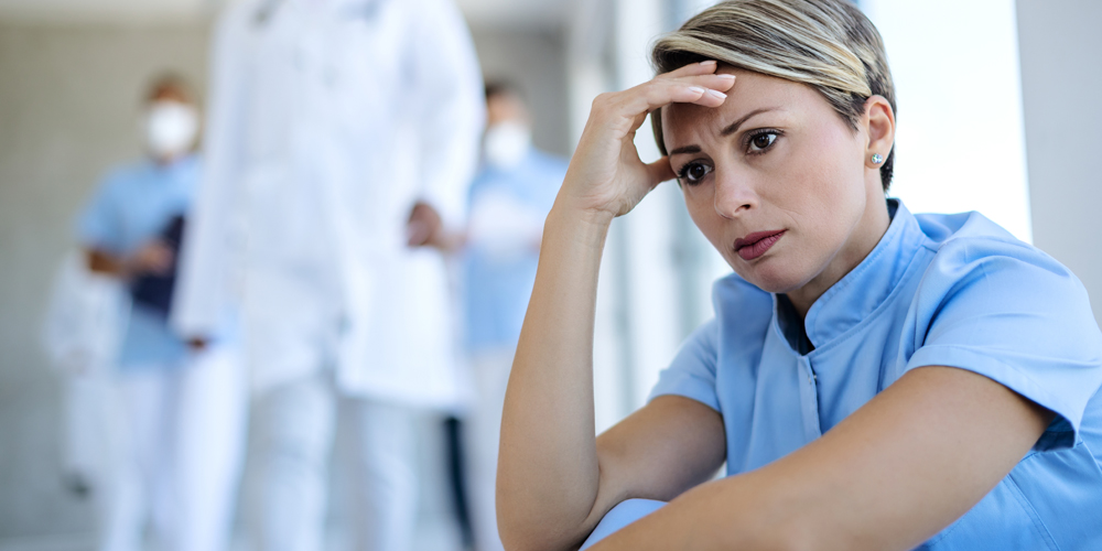 Five registered nurses within a healthcare facility working on a report.