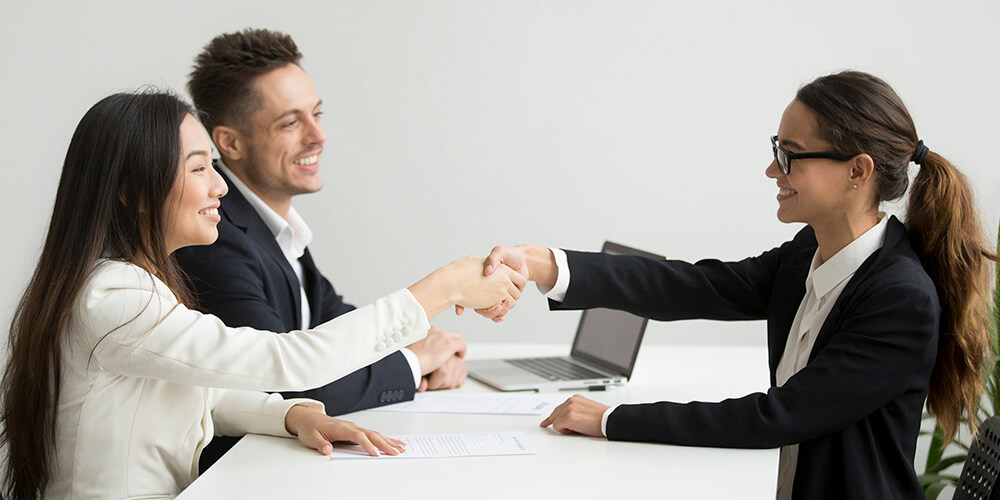 A professional nurse advocate converses with a nurse in an office.