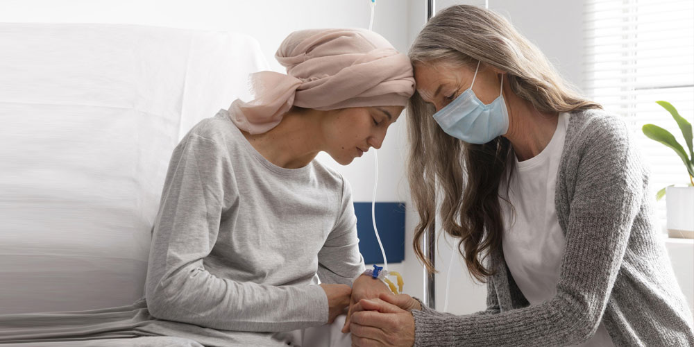 An oncology nurse holding hands of a patient providing compassionate support.