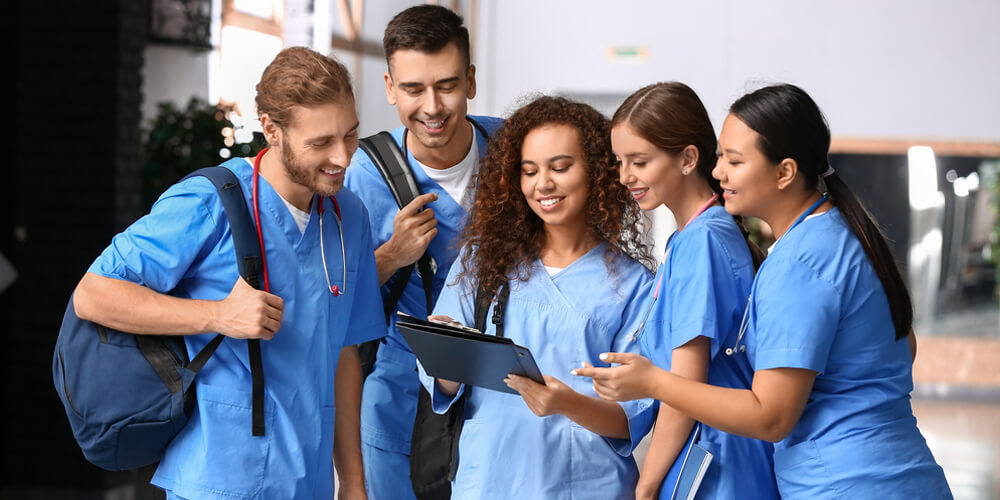 A group of nursing staff posing for a photograph in a hospital corridor.