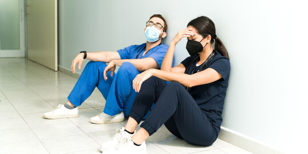 A group of nursing staff posing for a photograph in a hospital corridor.