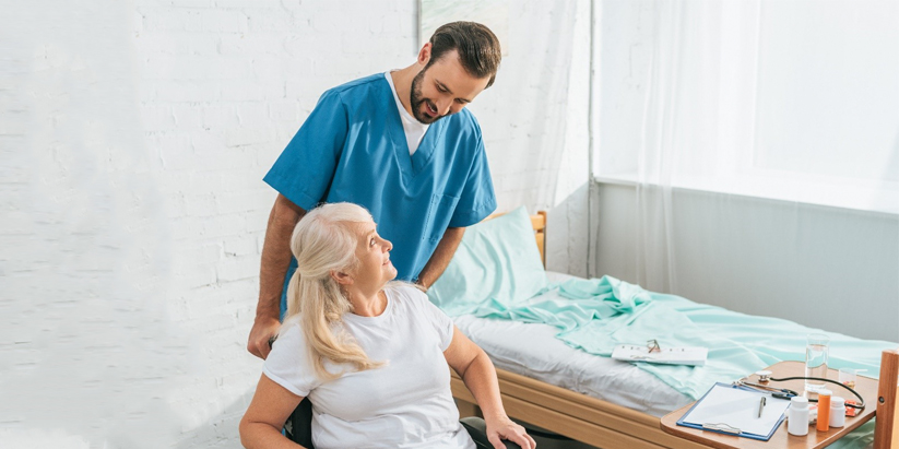 A support worker assists an elderly woman with her medication.