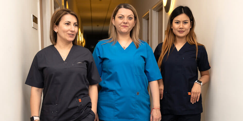 A nurse smiles as she poses for a photograph while holding a client file.