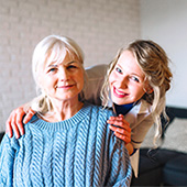 A nursing home resident and healthcare staff pose for a photo.