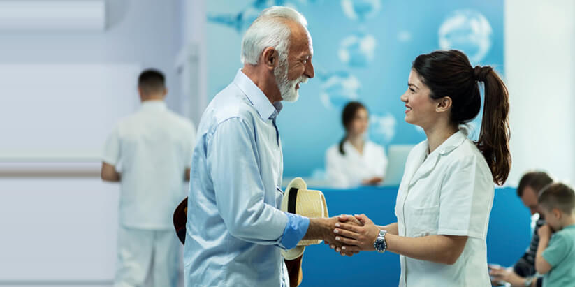 A nurse and an elderly patient read the directions on a medicine bottle.