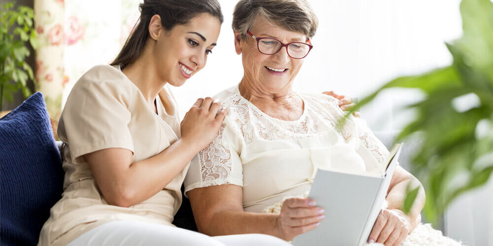 A healthcare worker with an elderly woman at a care home