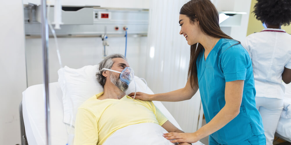 A nursing staff member standing outside a patient's treatment room.