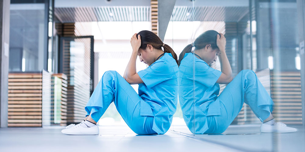 A nursing staff member standing outside a patient's treatment room.