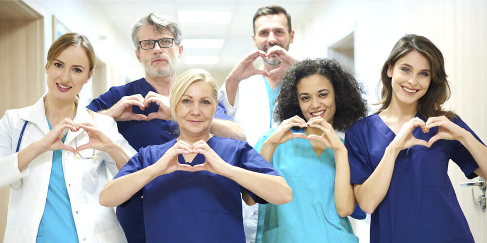 Happy nursing staff and healthcare professionals standing together