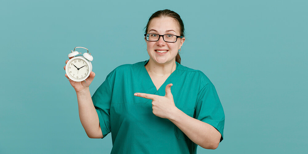 A smiling charge nurse in uniform holding a tab with patient records.
