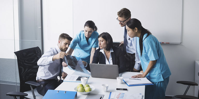 A group of permanent nurses and agency nurses reviewing a patient's report