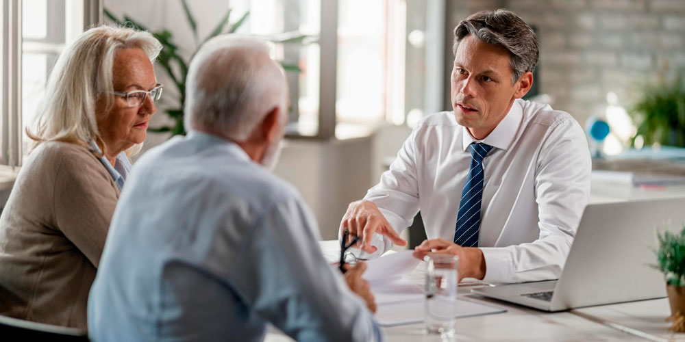 A professional nurse advocate converses with a nurse in an office.