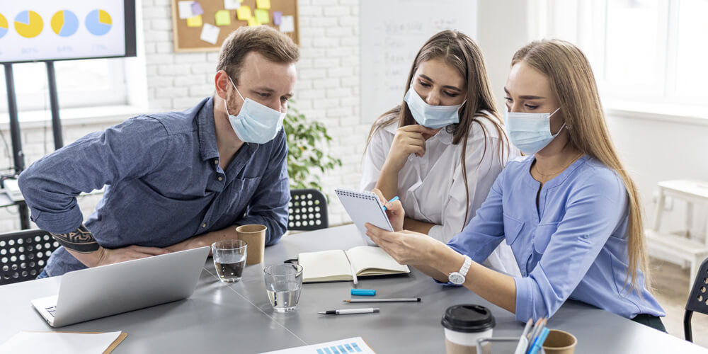 A Nurse professional wearing a mask and disposable gloves in their workplace.