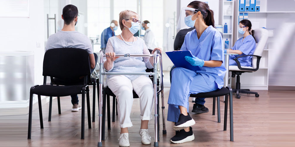 A nurse and an elderly patient read the directions on a medicine bottle.